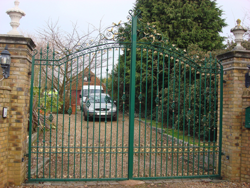 Green wrought iron driveway gates with door entry system. We made these gates in our factory.