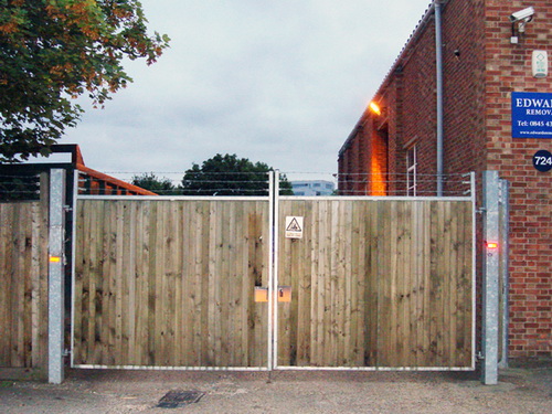 Iron framed wooden high security double gates.  3 levels of barbed wire for total security.